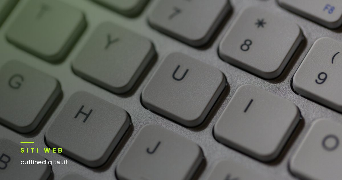 Tastiera di computer con le dita sopra, in primo piano
